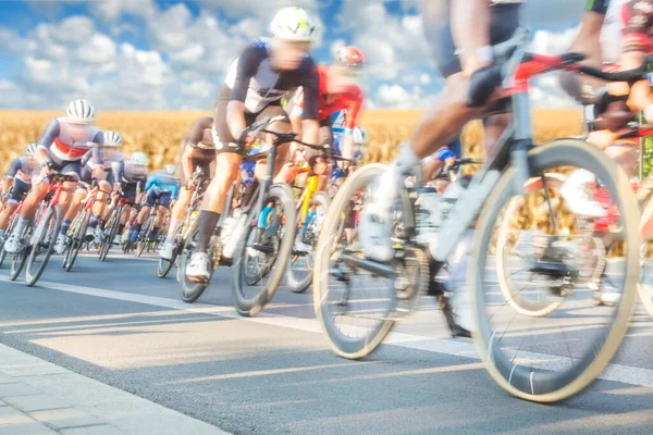 Radfahrergruppe Während Eines Rennens Sonnenlicht Verschwommenheit Bewölkter Himmel Hintergrund lizenzfreie Stockbilder