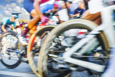 Group of Cyclists During a Race sunlit, motion blur, overcast sky in the background