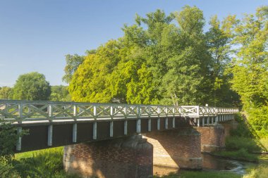 Muskauer Park 'taki Lusatian Neisse Nehri üzerindeki İngiliz Köprüsü Polonya-Almanya sınırı, yazın güneşli.