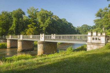 Muskauer Park 'taki Lusatian Neisse Nehri üzerindeki İngiliz Köprüsü Polonya-Almanya sınırı, yazın güneşli.