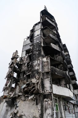 BORODYANKA, UKRAINE - 15 Kasım 2022: Rusya 'nın Kyiv yakınlarındaki Borodyanka' daki hava bombardımanlarıyla yıkılan ev üzerindeki Banksy graffiti. Genç jimnastikçi amuda kalkıp beton moloz yığınının üzerinde dengede duruyor.