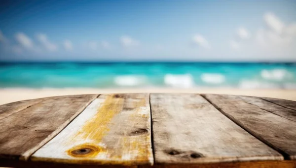 A wooden table with a view of the ocean in the background with a blurry image of the beach summer a tilt shift photo postminimalism