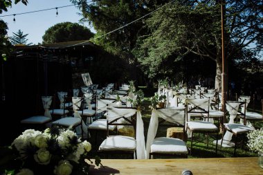 Süslü sandalyeli düğün kemeri ve güzel açık hava düğünü için çiçekler. 