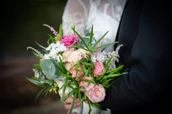 新娘和新郎手持美丽的婚礼花束 — 图库照片