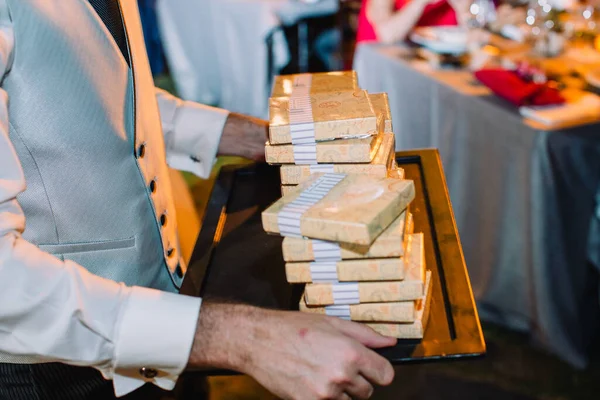 wedding reception. waiter holding chocoloate bars on a tray