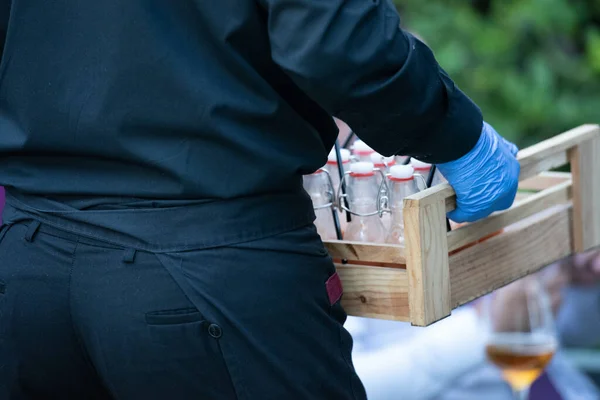 stock image waiter carrying box with water bottles 