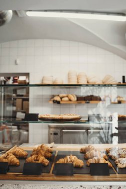 Interior details at the bakery and coffee shop. Bistro showcase with shelves of freshly croissants and bread in assortment. Zero waste shop or sustainable local small businesses at food service.