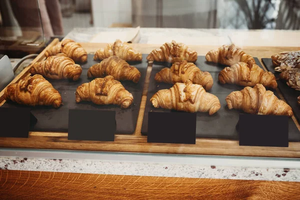 Interior details at the bakery and coffee shop. Bistro showcase with shelves of freshly croissants and bread in assortment. Zero waste shop or sustainable local small businesses at food service.