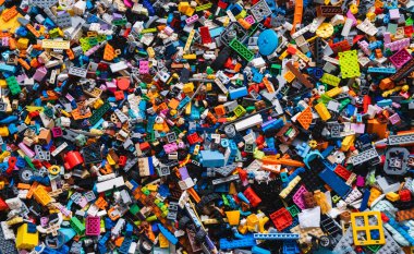 Karışık plastik inşaat tuğlalarının renkli arka planı oyuncakları. Birden fazla rengi olan küçük plastik bloklar, üst görünüm, yaşam tarzı fotoğrafı. Çocukların eğlencesi, çocukların eğitimi ve gelişimi.