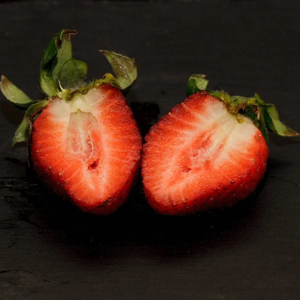 成熟的草莓放在黑暗的桌子上 — 图库照片