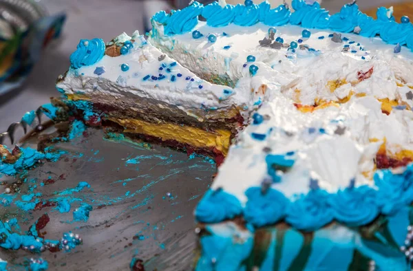 close - up of a blue and yellow colored cupcake with cream