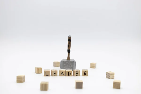 stock image The hammer is standing on the wooden cubes with the word LEADER against white background