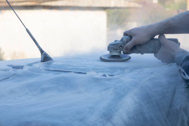 Araba tamircisinin elleri arabanın çatısını öğütüyor..