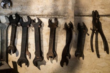 Ahşap sanayi duvarındaki eski anahtarlar. Eski grunge arka planına karşı bir çilingir duvarındaki araç