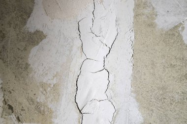 Duvarın arka planında çatlak olan alçı.
