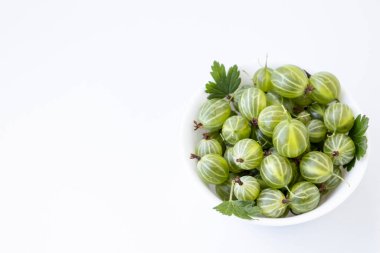 Beyaz arka planda beyaz tabakta yaprak yayları olan Bektaşi üzümü meyvesi. Lezzetli taze yeşil organik böğürtlen