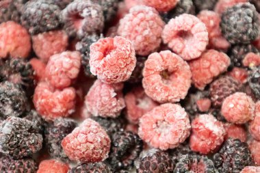 Healthy berry mix of frozen raspberries and blackberries. Frozen berries against background. clipart