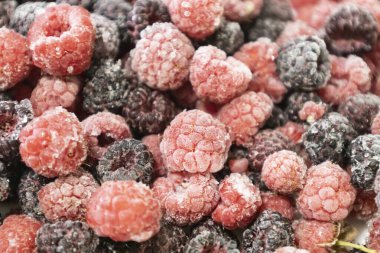 Healthy berry mix of frozen raspberries and blackberries. Frozen berries against background. clipart