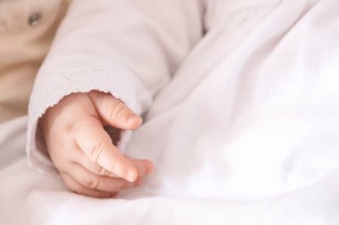 Bir çocuğun vaftiz töreni. Vaftizde giyecek küçük elleri olan bir vücut parçası.