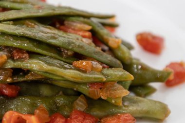 Domates ve soğanlı kızarmış yeşil fasulye. Akşam yemeğinde Fransız fasulyeli lezzetli yemek ya da beyaz arka planda öğle yemeği.