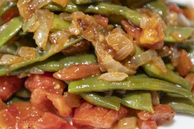 Domates ve soğanlı kızarmış yeşil fasulye. Akşam yemeğinde Fransız fasulyeli lezzetli yemek ya da beyaz arka planda öğle yemeği.