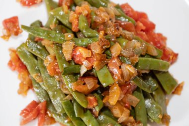 Domates ve soğanlı kızarmış yeşil fasulye. Akşam yemeğinde Fransız fasulyeli lezzetli yemek ya da beyaz arka planda öğle yemeği.