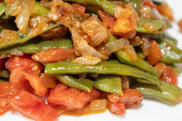 Domates ve soğanlı kızarmış yeşil fasulye. Akşam yemeğinde Fransız fasulyeli lezzetli yemek ya da beyaz arka planda öğle yemeği.