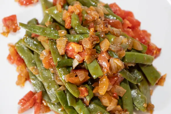 Domates ve soğanlı kızarmış yeşil fasulye. Akşam yemeğinde Fransız fasulyeli lezzetli yemek ya da beyaz arka planda öğle yemeği.