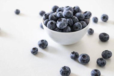 Yabanmersini lezzetli, sağlıklı ve lezzetli meyvelerdir. Beyaz kasede taze yaban mersini. Beyaz arka planda beyaz tabakta yabanmersini.