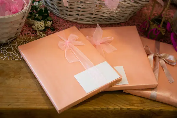 Подарочные Коробки Столе Белой Картой Розовыми Бантами Оранжевой Бумагой Стоковое Изображение