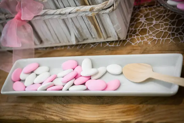 Weißes Und Rosafarbenes Italienisches Konfetti Oder Bonbons Auf Holztisch Stockfoto