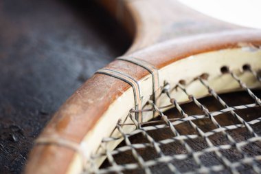 Eski ahşap tenis raketinin ayrıntıları. Teller, hasarlı ahşap çerçeve. Yumuşak ışıklar, bulanık ve yumuşak detaylar.