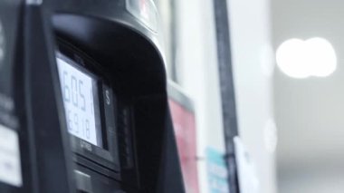 Benzin istasyonunda yakıt ikmali yaparken artan benzin fiyatlarını gösteren bir benzin pompası ekranı.. 