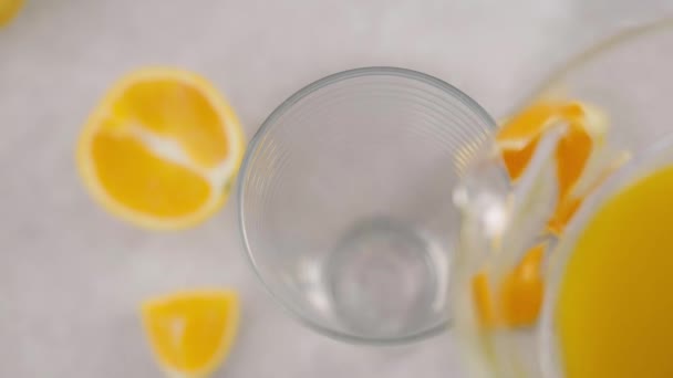グラスに注ぐオレンジジュース トップビュー スローモーション クローズアップ — ストック動画