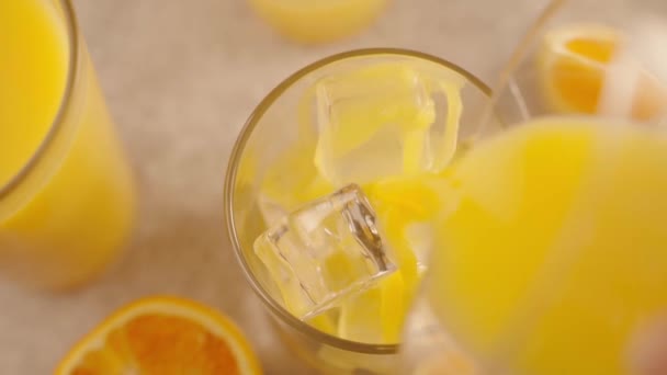 Orange Juice Pouring Ice Cubes Glass Slow Motion Close — Stock Video