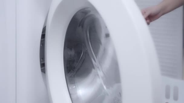 洗濯機からきれいな服を取って家で洗濯をしている女性 — ストック動画
