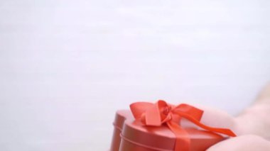 Celebration concept, Man giving gift to woman for St. Valentines Day, Mothers Day, birthday, Womans Day, Christmas. Present for holiday. Wrapped gift box with red ribbon bow in male hands.