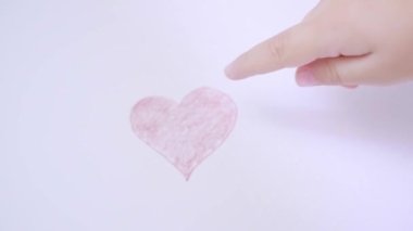 Close up of child hand showing hand drawn red heart to his mother on white pastel background. Family relationship, family, wellness concept. Relation between parents and kids, mother, father and child