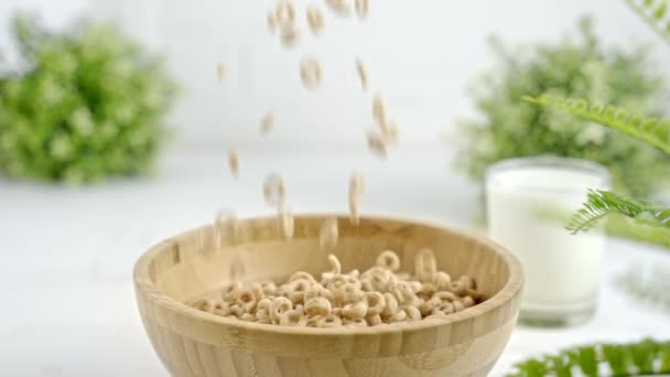 麦片缓缓地掉进一个白色明亮厨房里的木碗里 关上了门 健康早餐的圆形全麦谷类 — 图库视频影像