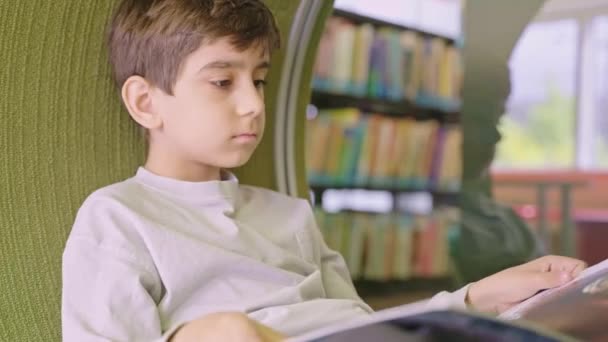 Cute Caucasian Little Boy Sitting Floor Reading Book Library — Stock Video