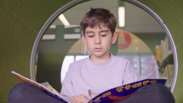 Sevimli Beyaz Çocuk Yerde Oturuyor Kütüphanede Kitap Okuyor — Stok video