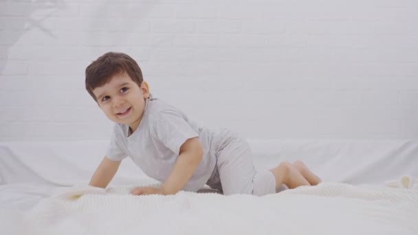 白人小孩在床上跳得很开心 幸福和青年的概念 — 图库视频影像