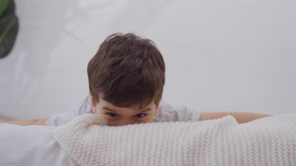 Glimlachend Jongetje Dat Plezier Beleeft Bed Met Wit Vers Beddengoed — Stockvideo