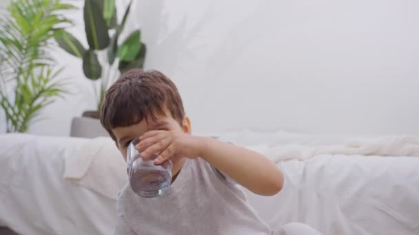 可爱的笑着的小男孩喝了一杯清澈的过滤矿泉水 健康的生活方式 健康的童年 慢动作 特写的概念 — 图库视频影像