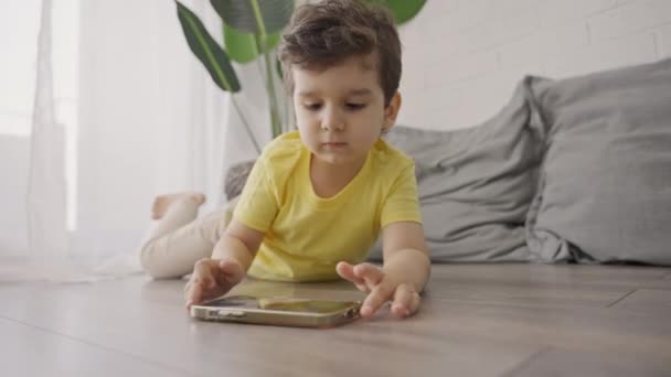 Niño Pequeño Que Toma Teléfono Inteligente Piso Comienza Jugar Juegos — Vídeos de Stock
