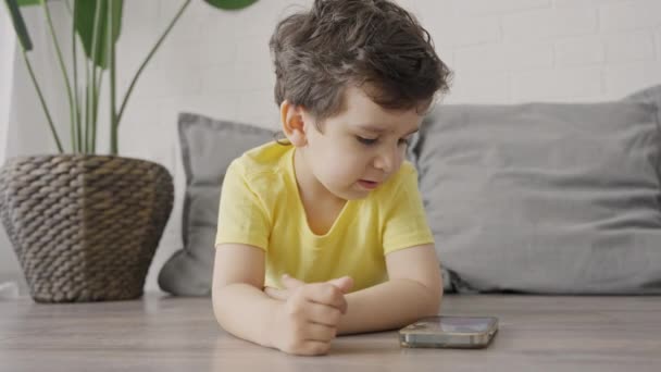 Χαριτωμένο Μικρό Αγόρι Απολαμβάνουν Χρήση Σύγχρονων Gadget Έξυπνο Τηλέφωνο Κοιτάζοντας — Αρχείο Βίντεο