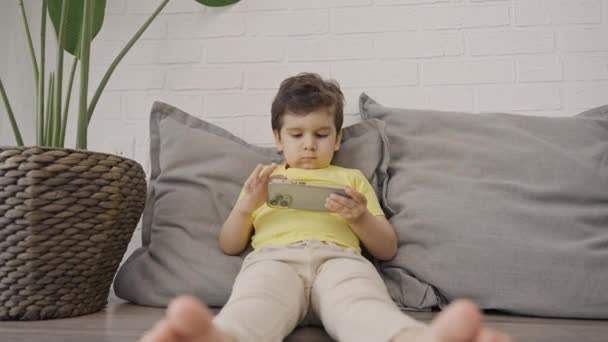 Χαριτωμένο Μικρό Αγόρι Χρησιμοποιώντας Έξυπνο Τηλέφωνο Κοιτάζοντας Οθόνη Κυττάρων Απολαμβάνοντας — Αρχείο Βίντεο