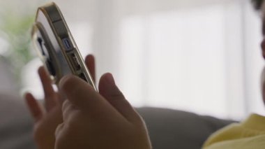 Childs 'ın elleri cep telefonunu tutarken ekranlara dokunurken video oyunları oynarken, eğlenirken, online oyunlar oynarken. Kapalı alanda cep telefonu kullanan modern teknoloji çocuğuna bağımlı.