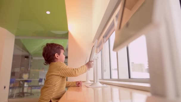 Милий Маленький Хлопчик Розважається Цифровим Планшетом Бібліотеці — стокове відео