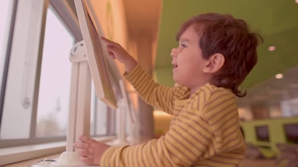 Sonriente Niño Que Divierte Con Aplicación Digital Tocando Pantalla Tableta — Vídeos de Stock